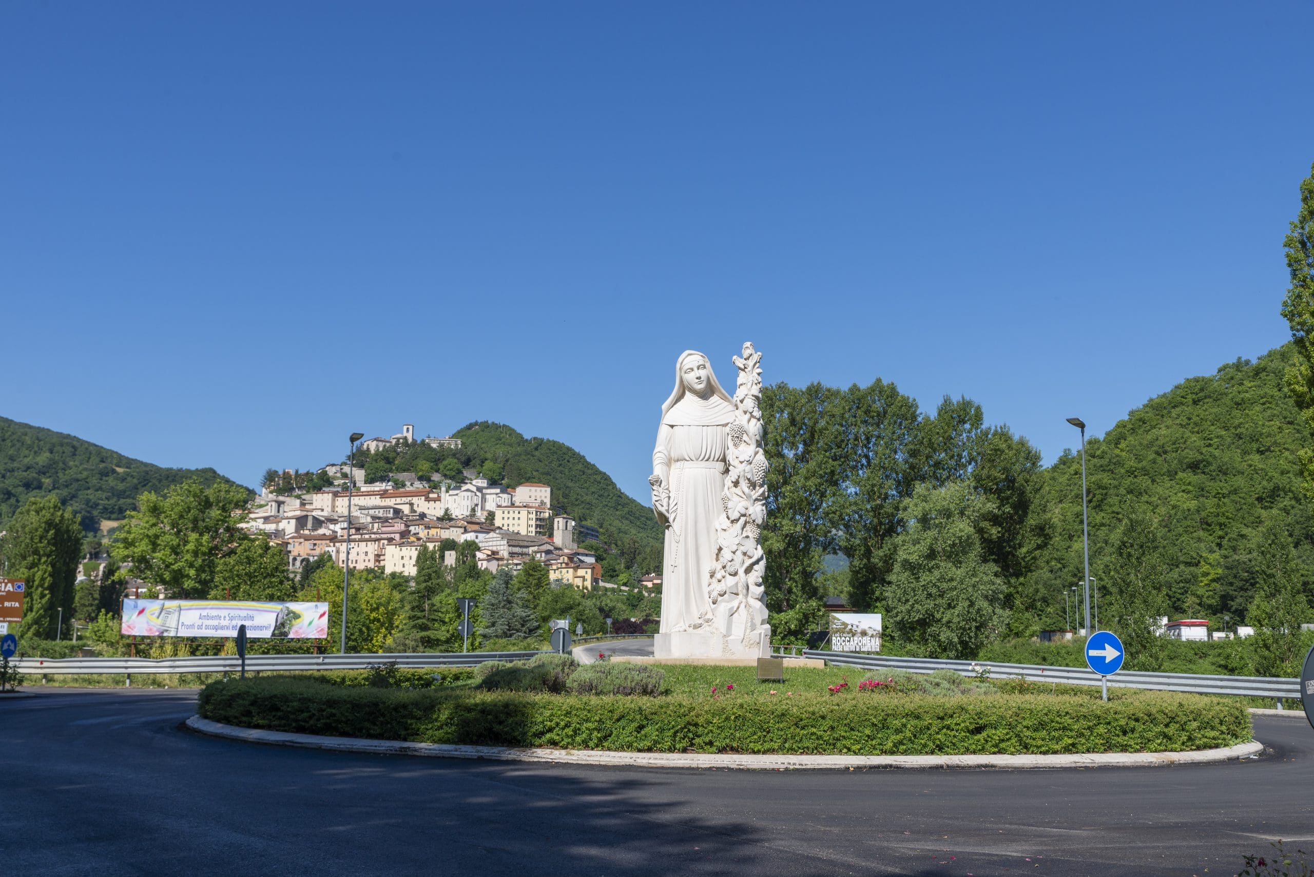 cascia,italy july 05 2020:rotunda with monument of saint rita and behind in the background cascia